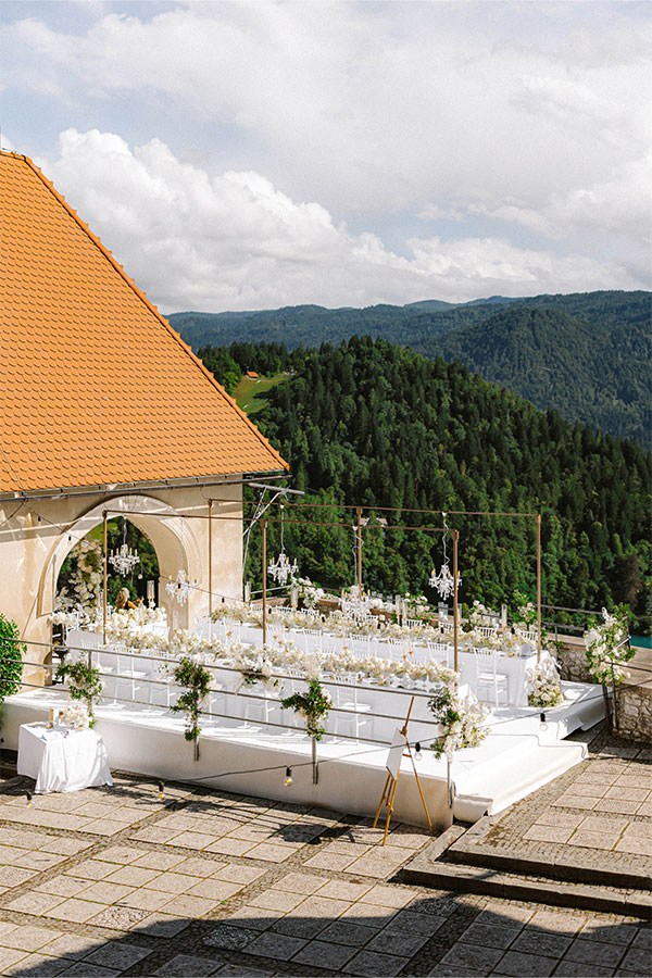 Elegant 2025 Lake Bled wedding reception setup at Bled Castle with bespoke floral design and mountain views