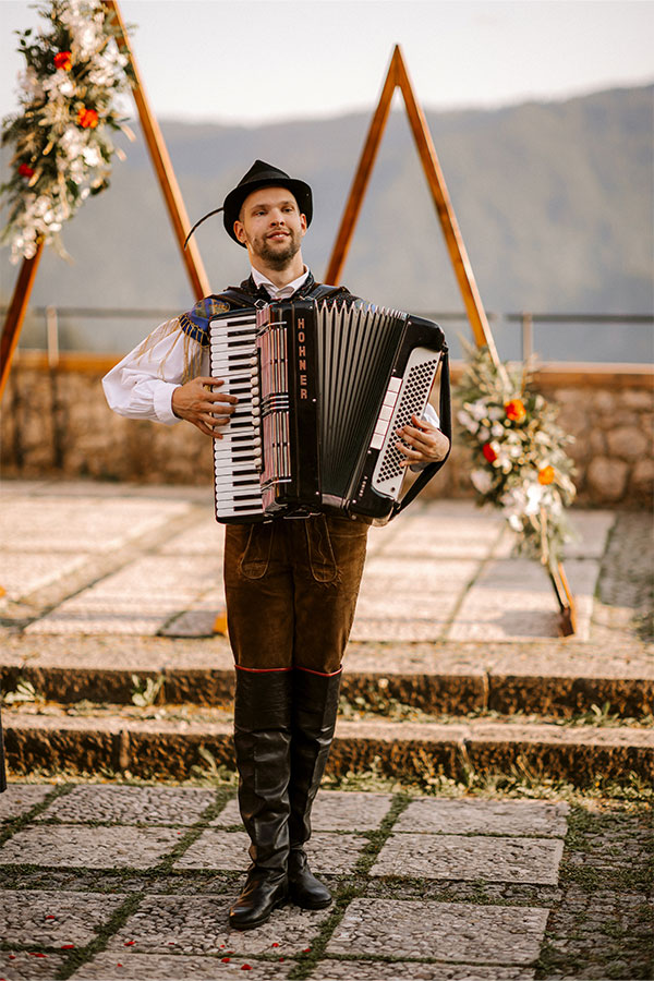 A closeup shot of a male playing the accordion during lake Bled wedding at lake Bled Castle.