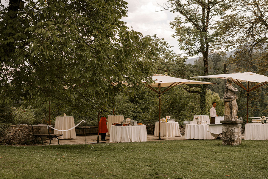 Tables with white table cloths at wedding reception after church wedding on lake Bled Island.