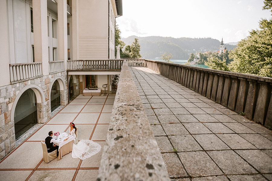 The romantic groom and bride in love sitting in the vila Bled terrace.