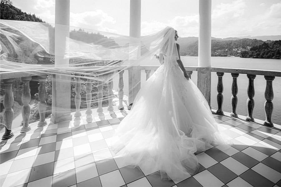 Black and white photo of a Bride in a princess dress with a long veil at Grand hotel Toplice balcony.