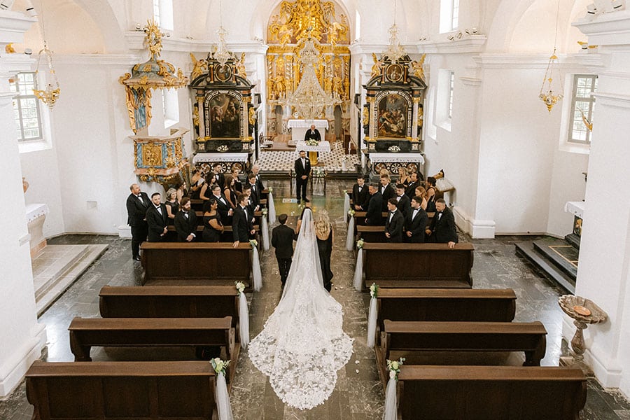Romantic wedding ceremony inside the iconic Lake Bled Island Church, with a bride walking down the aisle toward the ornate altar.