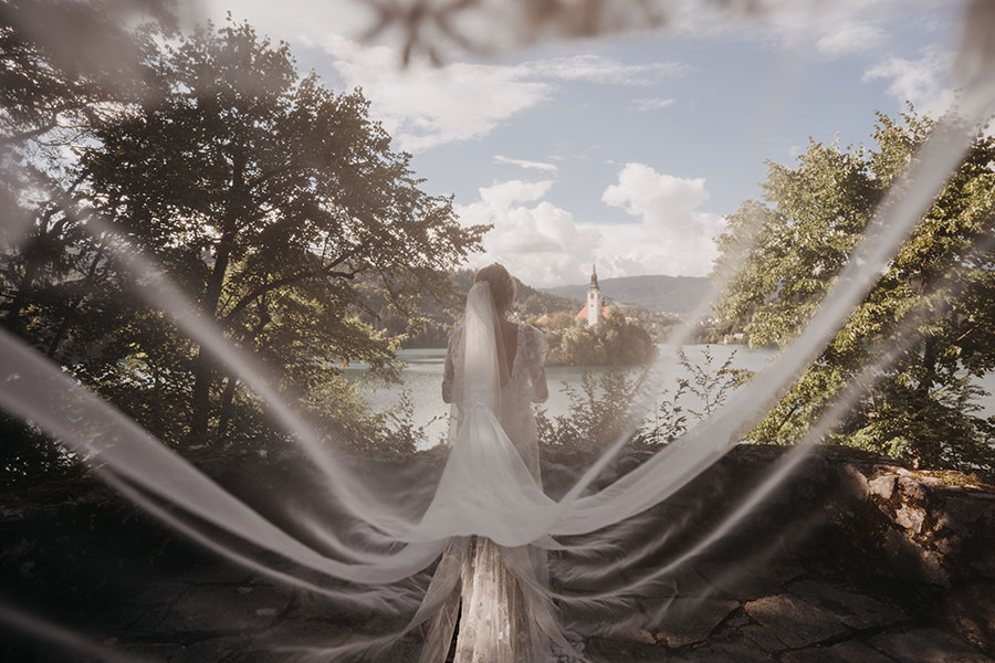 Back photo of a Bride looking at Lake Bled island from Vila Bled.