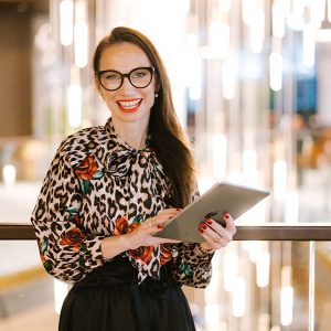 Petra Starbek, Lake Bled wedding planner in Slovenia, smiling and holding a tablet during planning work