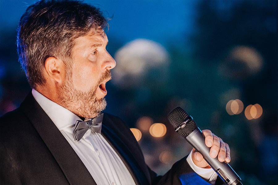 Opera singer with his microphone sing a Viva Per Lei at wedding dinner in Lake Bled.