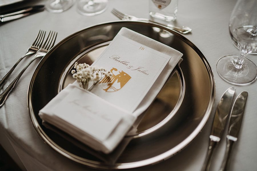 White napkin, wedding menu and white baby breath on a silver plate at wedding by the Lake Bled.