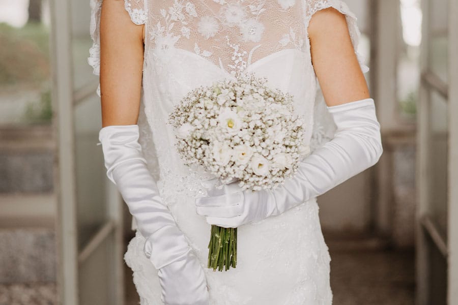 Beautiful Bride holds her white wedding bouquet.