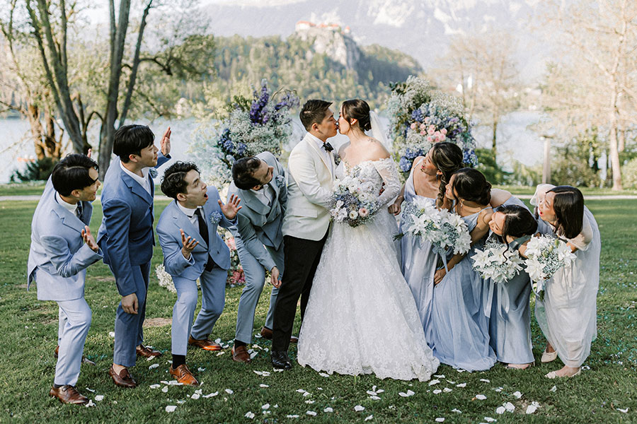 Couple kissing with friends cheering during a Lake Bled wedding, Slovenia.