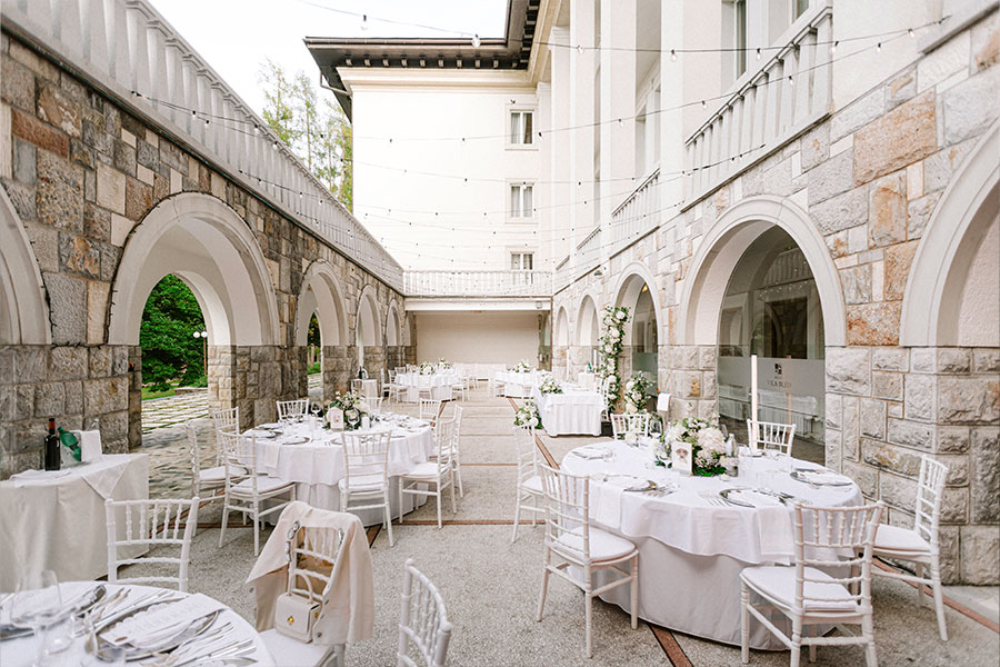 Elegant wedding reception setup on the terrace of Vila Bled with white table décor and stone archways.