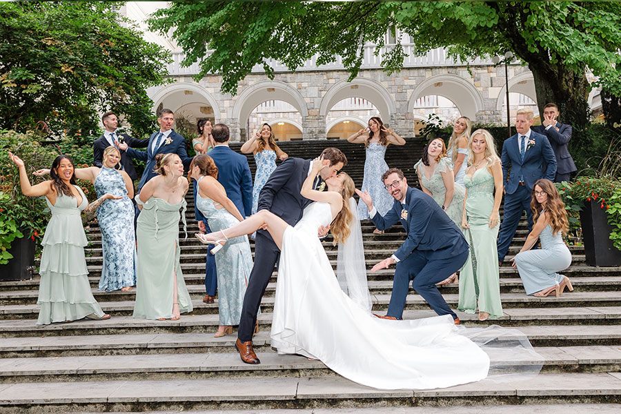 Fun wedding party group photo on steps at a Lake Bled wedding – effortless, joyful celebration.