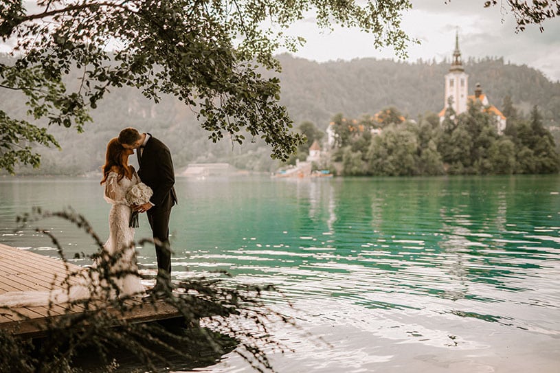 Couple sharing a quiet moment during their Lake Bled wedding by the lake and island church.