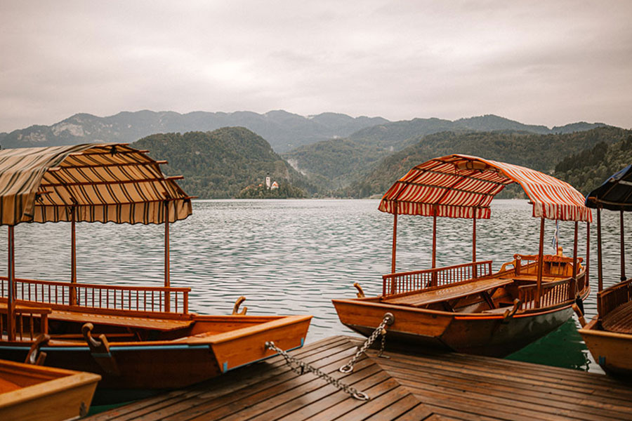 Traditional pletna boats on Lake Bled used for wedding transport to Bled Island, a key element of planning a Lake Bled wedding 10–15 K€.