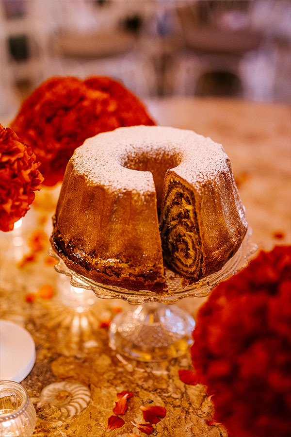A traditional holiday pastry Potica stands on glass on a decorated table during the wedding at Bled Castle wedding.