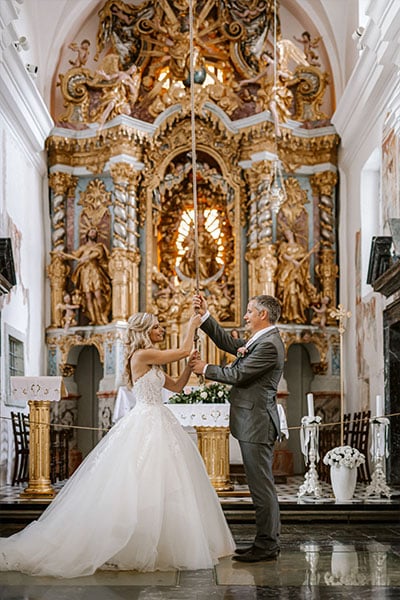 An amazing groom with his bride rings a wishing bell in Lake Bled Island Church.