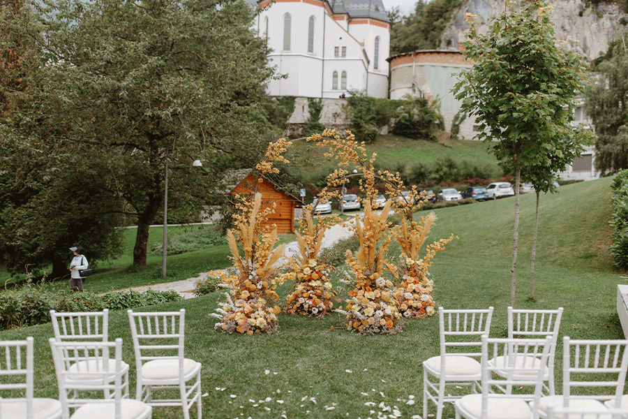 Two halfcircle yellow flower arches for lake bled wedding ceremony at Rose Bled hotel.