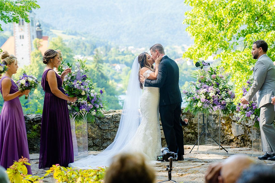 Bride and groom kiss at during their wedding ceremony at vila Bled terrace.